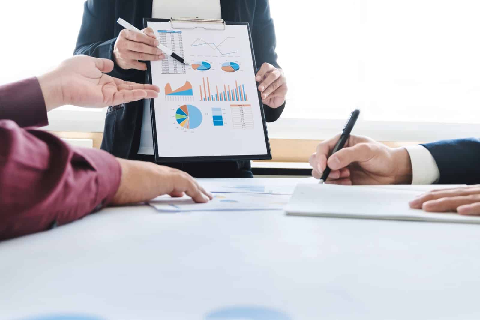 Man in suit displaying graphs for two people