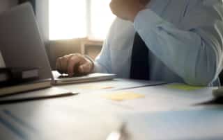 Man in Tie looking at Notebook computer